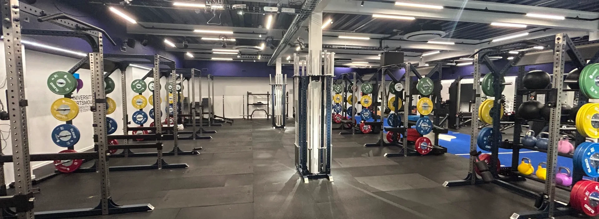 Interior of the large gym area of University of Portsmouth, with multi coloured weights.