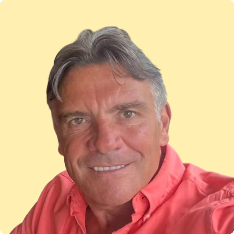 Rich, a white male with orange shirt, smiling at the camera.